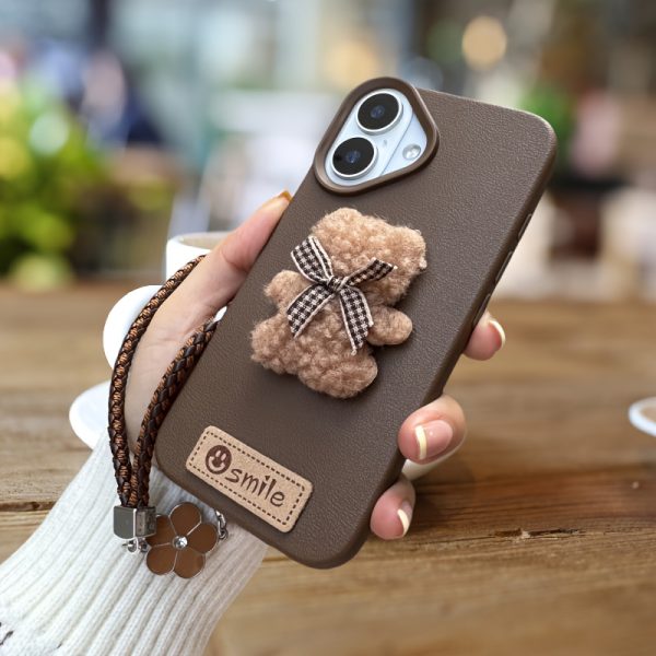 A Single-Pack Plush Teddy Bear Phone Case with a Bow, Available in White And Brown. It Comes with a Wrist Strap And Features a Simple And Elegant Faux Leather Texture That Is Anti-Slip And Fingerprint-Resistant. Made with TPU Full-Wrap Soft Rubber Technology, It Is Suitable for Apple Iphone Models Including XS, Xr, Xsmax, 11, Pro, Max, 12Pro, 13, Promax, 14, 14Pro, 14Promax, 15, 15Pro, 16, 16Pro, And 16Promax. - Image 5